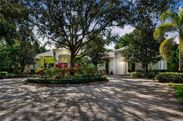 a front view of a house with a yard and a garden