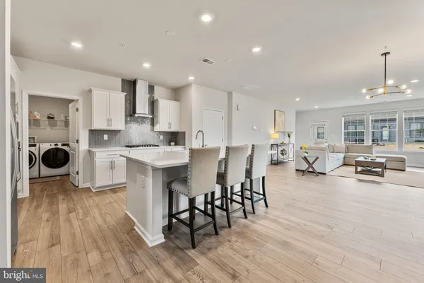 a open kitchen with stainless steel appliances granite countertop a dining table chairs stove a sink and a microwave