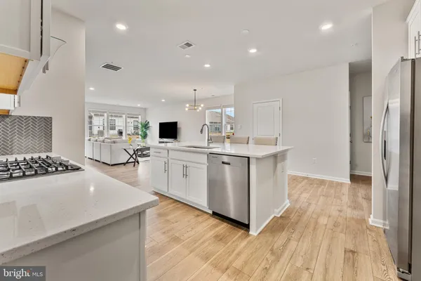 a large white kitchen with a stove a sink dishwasher and a refrigerator