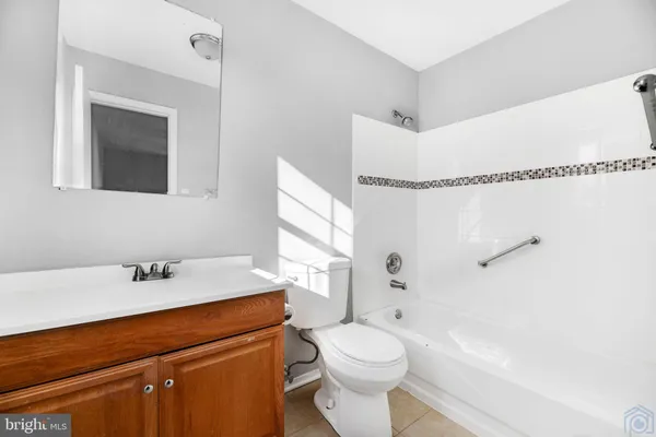 an empty room with wooden floor ceiling fan and windows