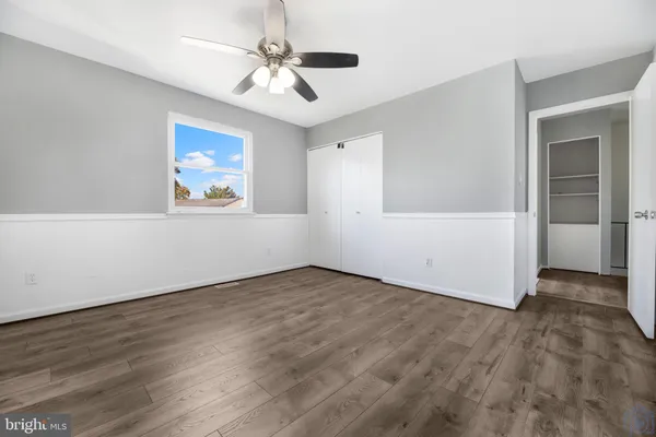 an empty room with ceiling fan and window