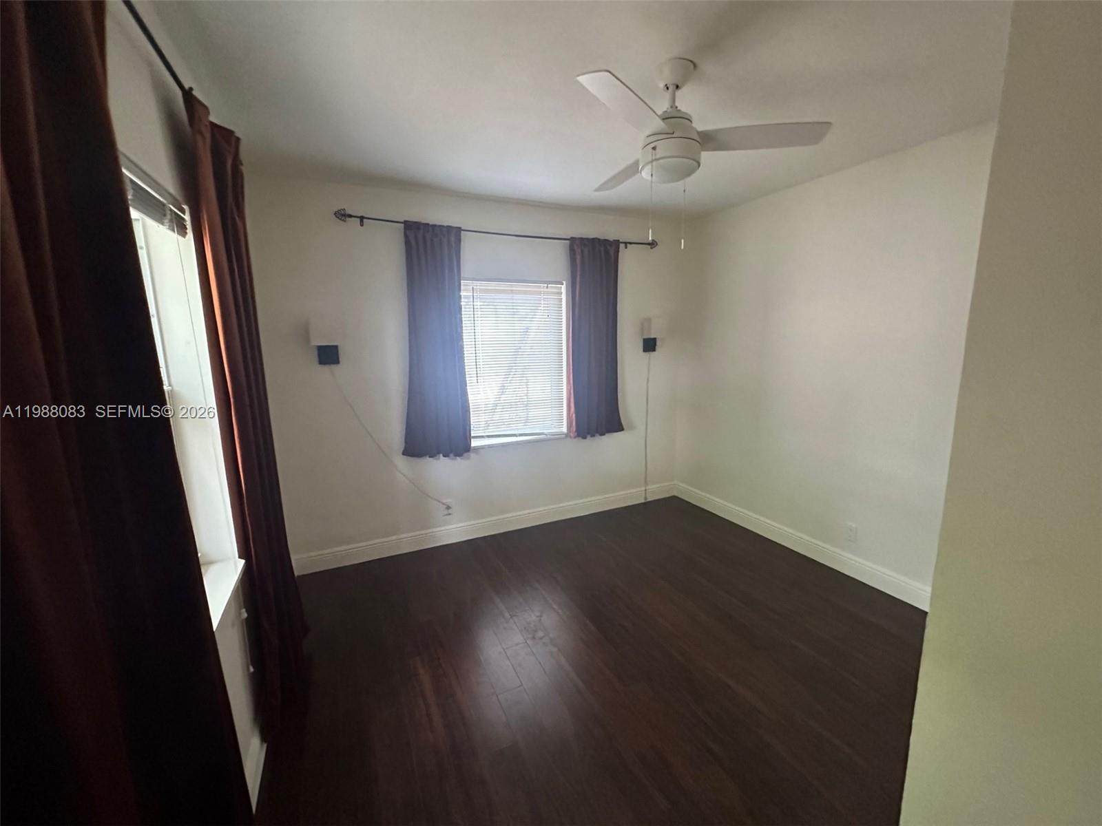 565 Northeast 65th Street, Unit 2 Miami, FL 33138 - Photo 5 of 7 an empty room with wooden floor and windows