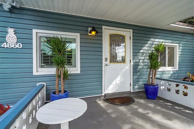 a view of a patio with table and chairs and potted plants