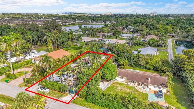 an aerial view of residential houses with outdoor space and trees