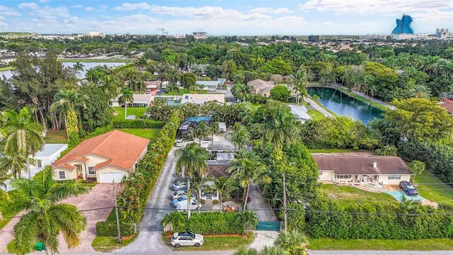 an aerial view of residential houses with outdoor space and trees