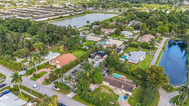 an aerial view of residential houses with outdoor space and swimming pool