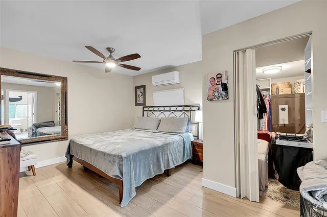 a spacious bedroom with a large bed a chandelier and dresser