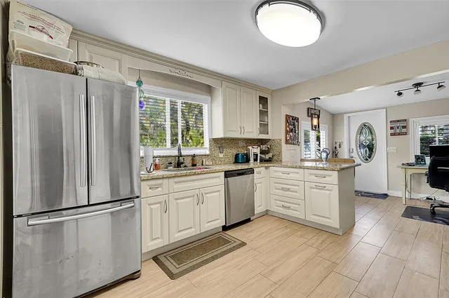 a kitchen with white cabinets and white appliances