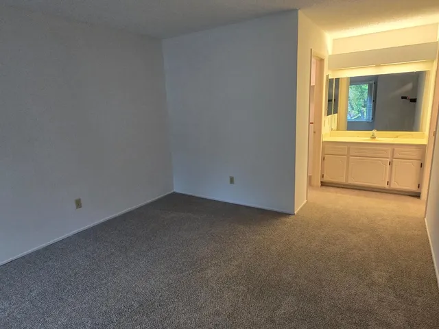 a view of a room with a sink and cabinet area