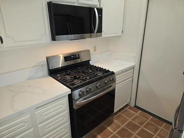 a stove top oven sitting inside of a kitchen