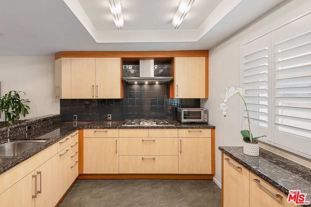 13214 Fiji Way, Unit P Marina del Rey, CA 90292 - Photo 14 of 41 a kitchen with granite countertop a sink and a white wooden cabinets