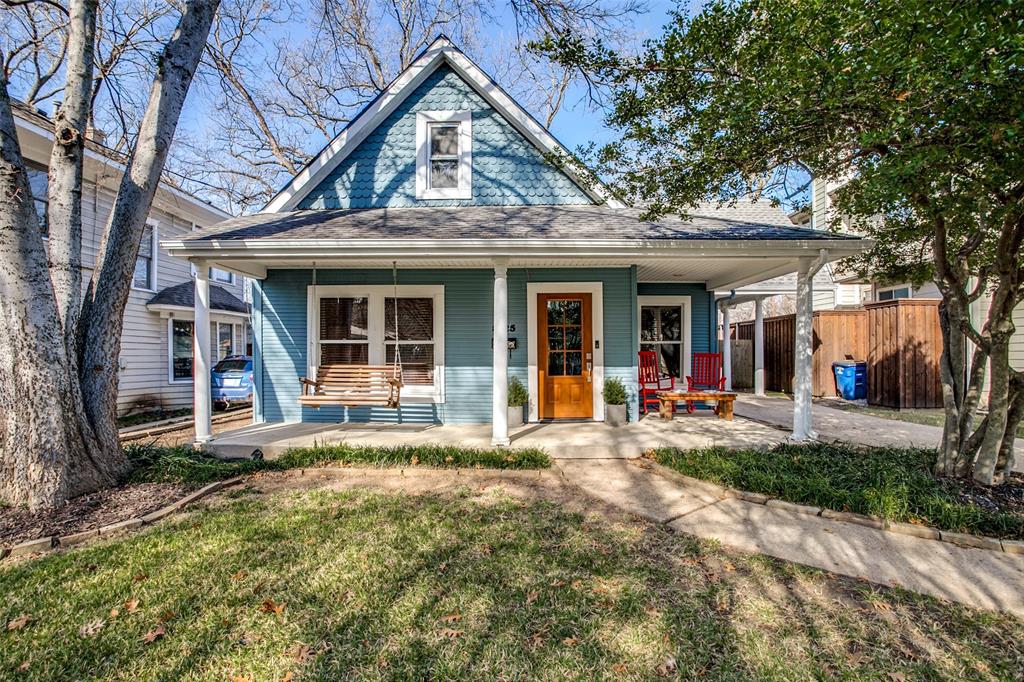 a view of a brick house with large windows and large tree