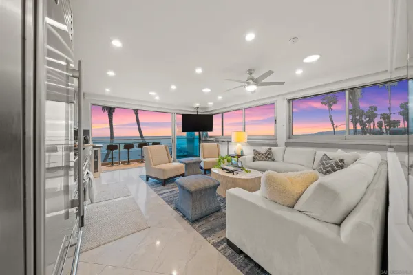 a living room with furniture kitchen view and a large window