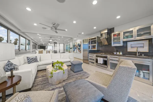 a living room with furniture kitchen view and a large window