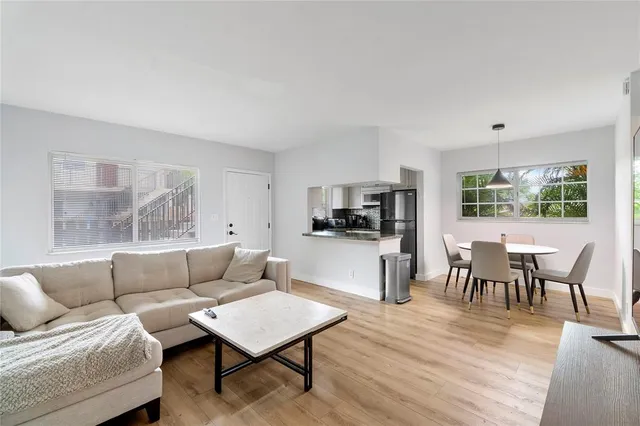 a living room with furniture a dining table and kitchen view