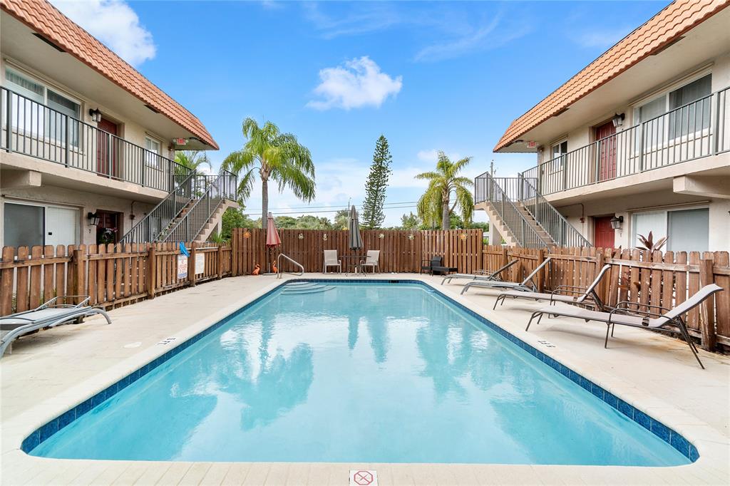 3030 Northeast 5th Terrace, Unit 1 Wilton Manors, FL 33334 - Photo 14 of 22 a view of a swimming pool with a lounge chairs