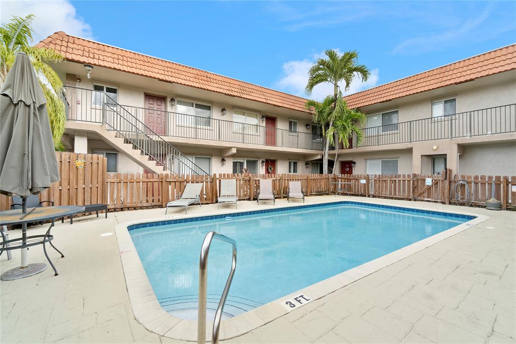 3030 Northeast 5th Terrace, Unit 1 Wilton Manors, FL 33334 - Photo 15 of 22 a view of a building with a swimming pool and sitting area