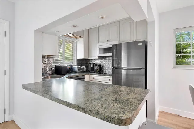 a kitchen with kitchen island a counter top space a sink and refrigerator