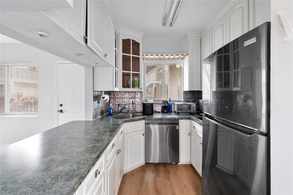 3030 Northeast 5th Terrace, Unit 1 Wilton Manors, FL 33334 - Photo 3 of 22 a kitchen with stainless steel appliances granite countertop a sink stove and refrigerator