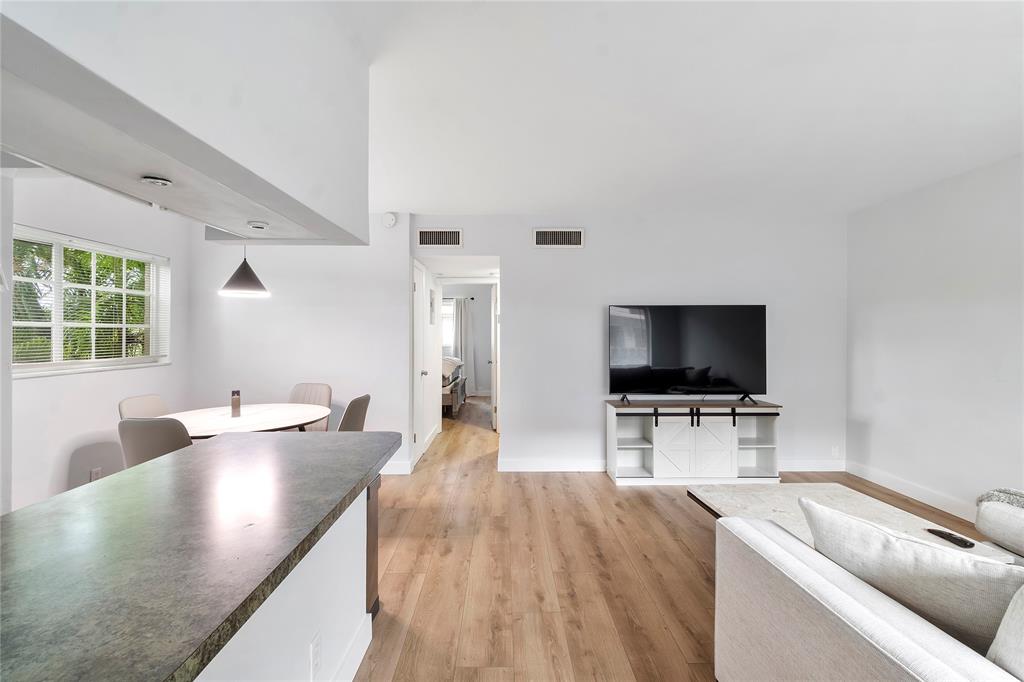 3030 Northeast 5th Terrace, Unit 1 Wilton Manors, FL 33334 - Photo 4 of 22 a living room with furniture and a flat screen tv