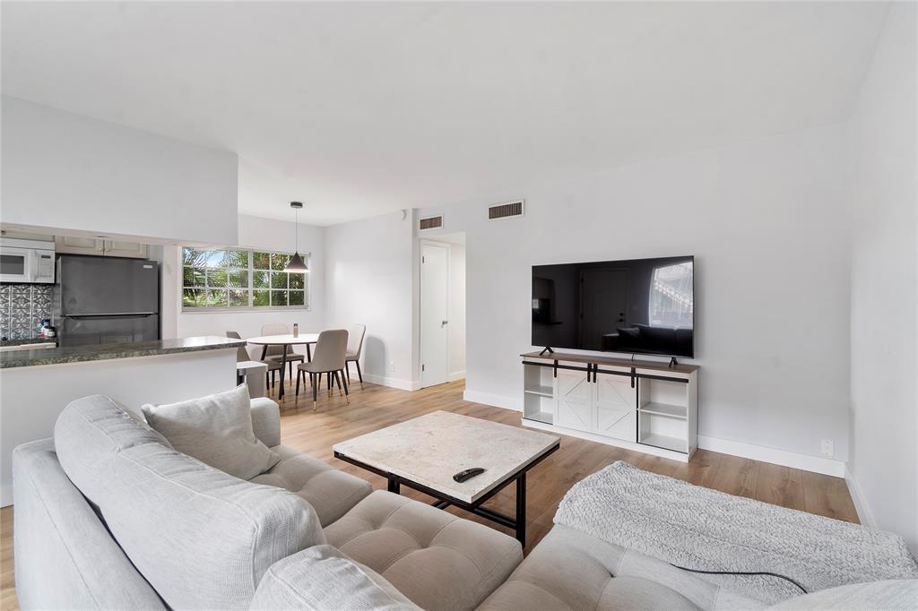 3030 Northeast 5th Terrace, Unit 1 Wilton Manors, FL 33334 - Photo 5 of 22 a living room with furniture and a flat screen tv