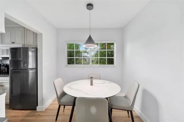 a kitchen with stainless steel appliances a dining table chairs and a window