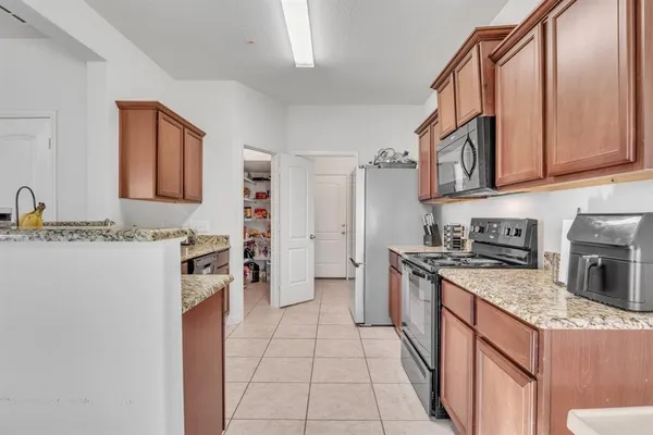 a kitchen with stainless steel appliances granite countertop a stove a sink and a refrigerator