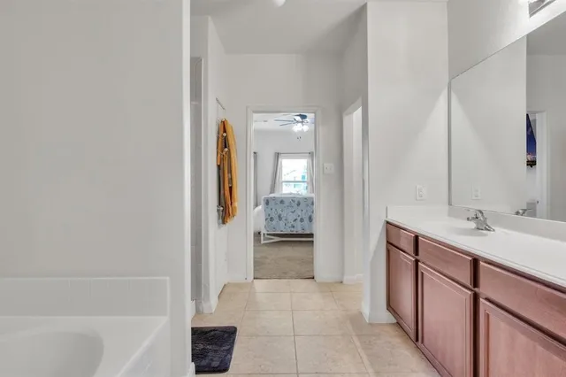 a bathroom with a bathtub sink and mirror