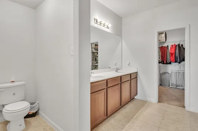 a spacious bathroom with a toilet sink and mirror