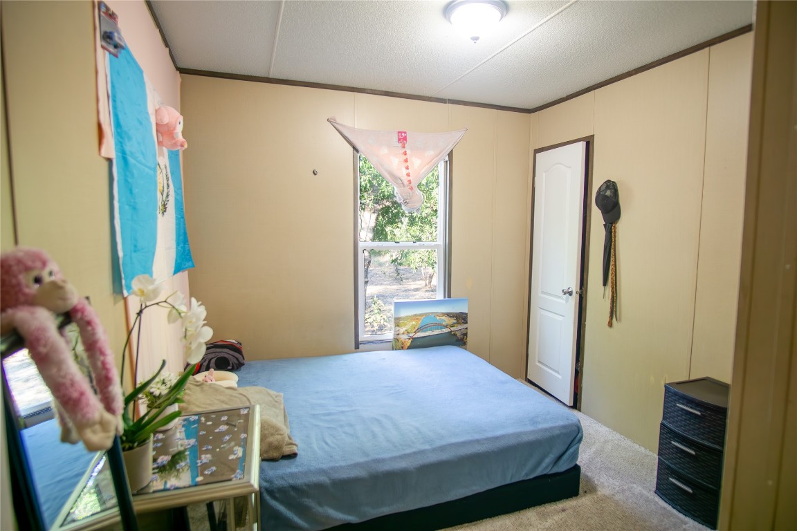 205 Arrowhead Cove Kyle, TX 78640 - Photo 11 of 20 a bedroom with a bed and a chair