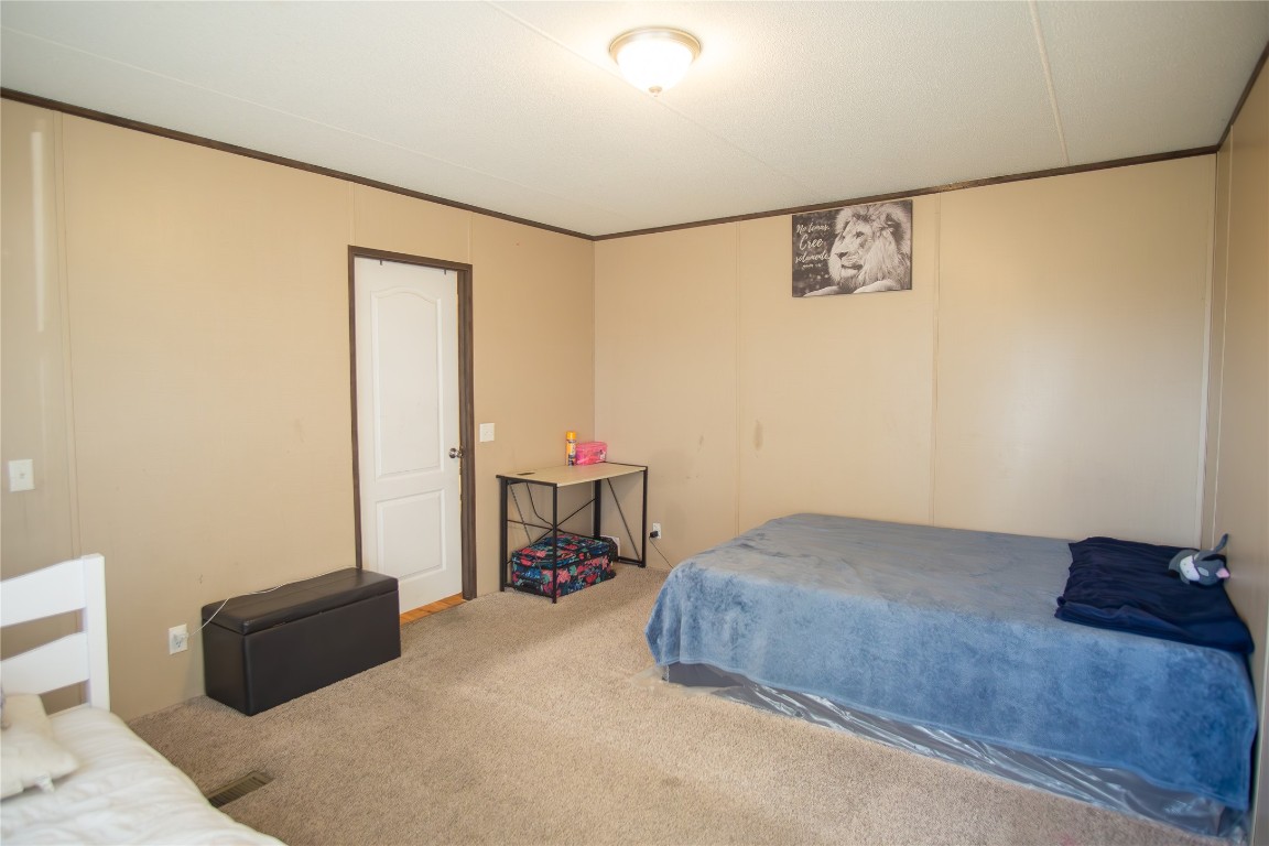 205 Arrowhead Cove Kyle, TX 78640 - Photo 8 of 20 a bedroom with a bed and a table in it