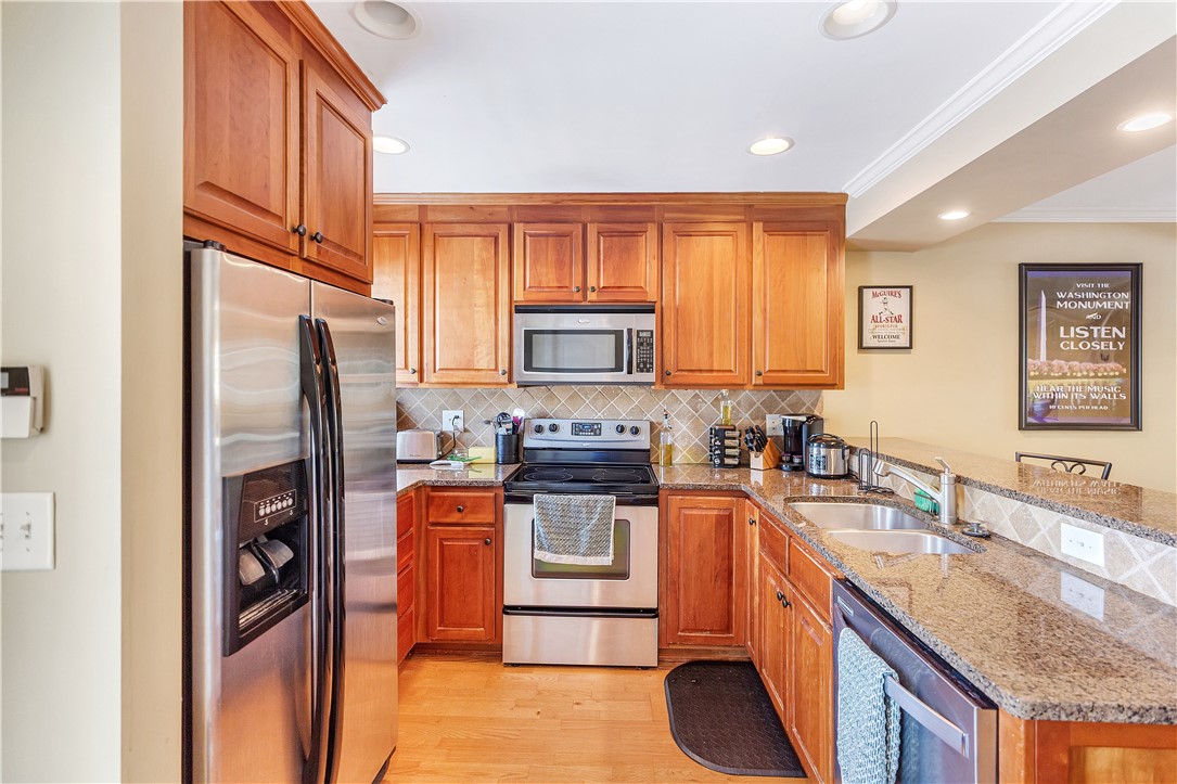209 Calhoun Street Clemson, SC 29631 - Photo 10 of 25 Rich wood cabinetry and polished stone countertops elevate this efficiently designed kitchen.