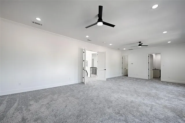 an empty room with window and ceiling fan