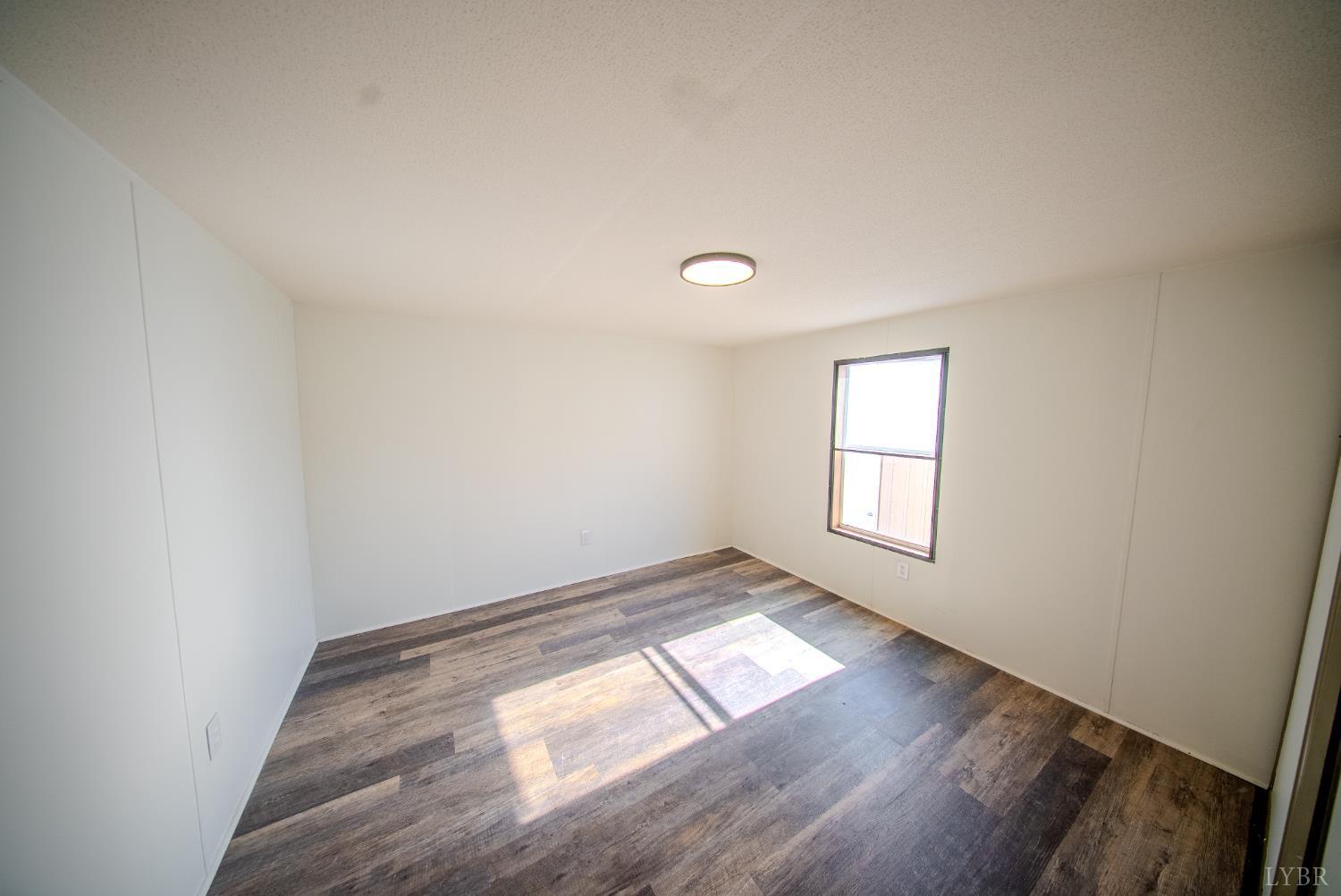 920 Hodnetts Road Gretna, VA 24557 - Photo 18 of 31 an empty room with wooden floor and windows