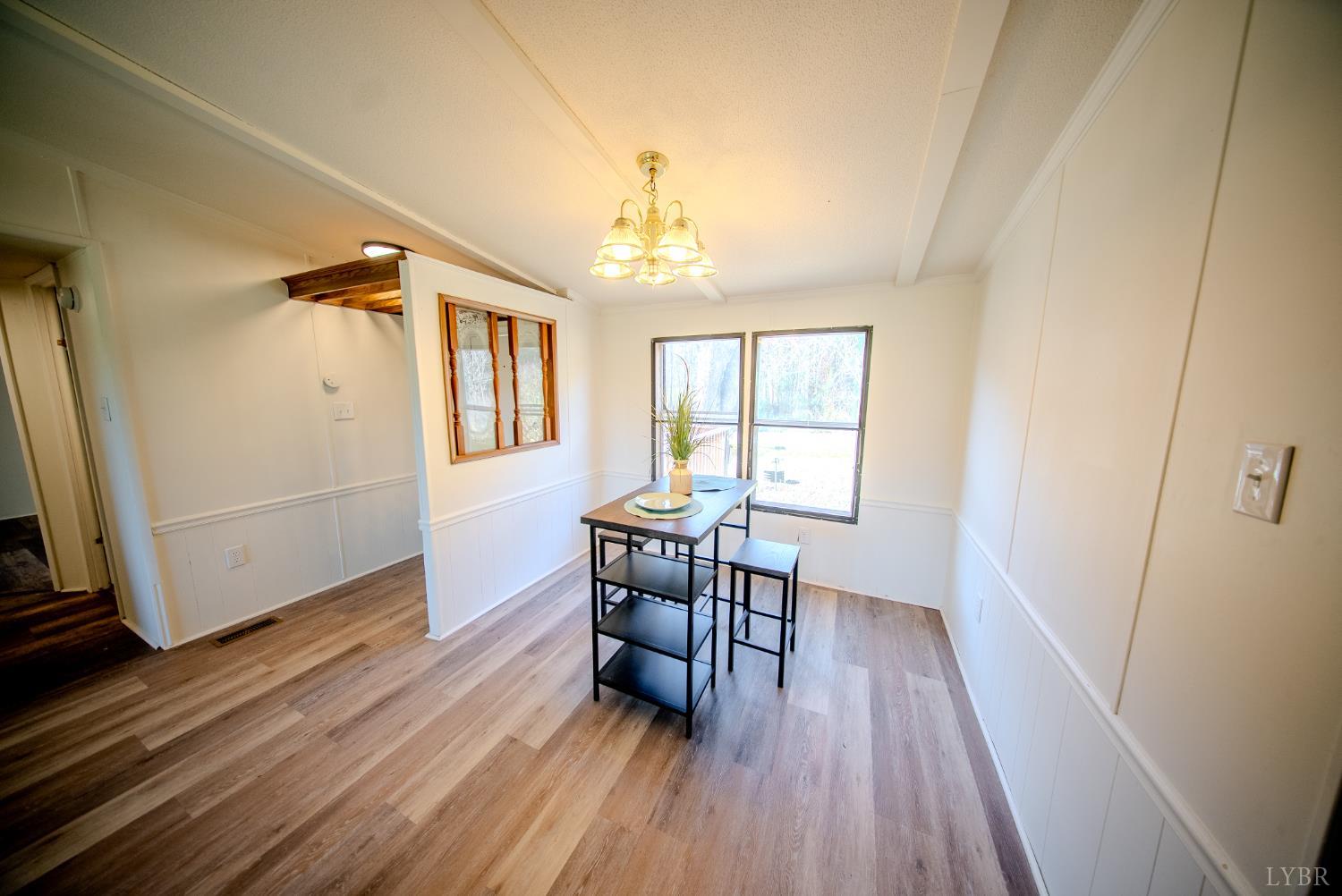 920 Hodnetts Road Gretna, VA 24557 - Photo 7 of 31 a dining room with wooden floor a chandelier a glass table and chairs