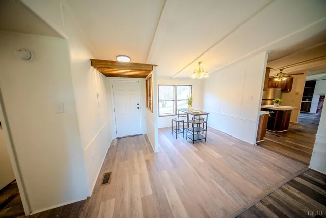 a hallway with wooden floor table and chairs