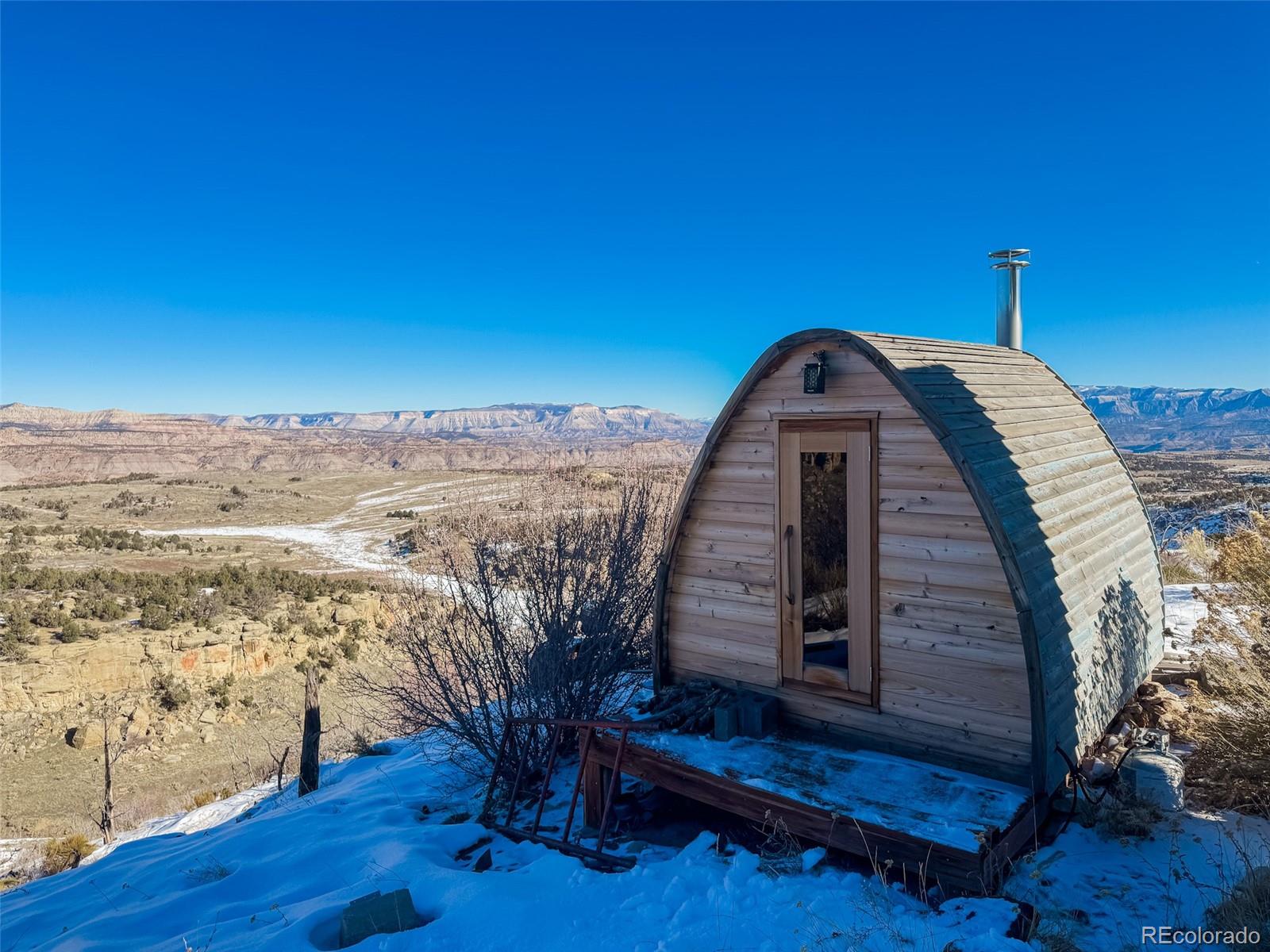 1725 35 1/10 Road De Beque, CO 81630 - Photo 30 of 36 a view of a balcony with wooden floor and a bench