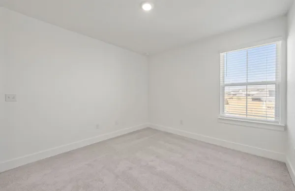 en empty room with windows and ceiling fan
