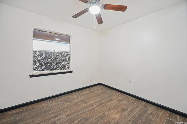 an empty room with a window and a ceiling fan