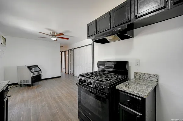 a kitchen with stainless steel appliances kitchen island a wooden floor a stove and a refrigerator