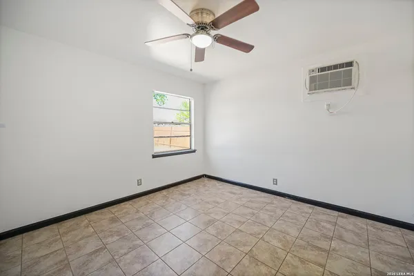 an empty room with windows and fan