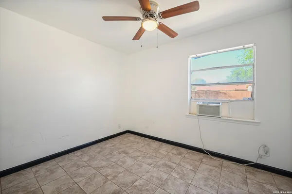 an empty room with a window and a fan