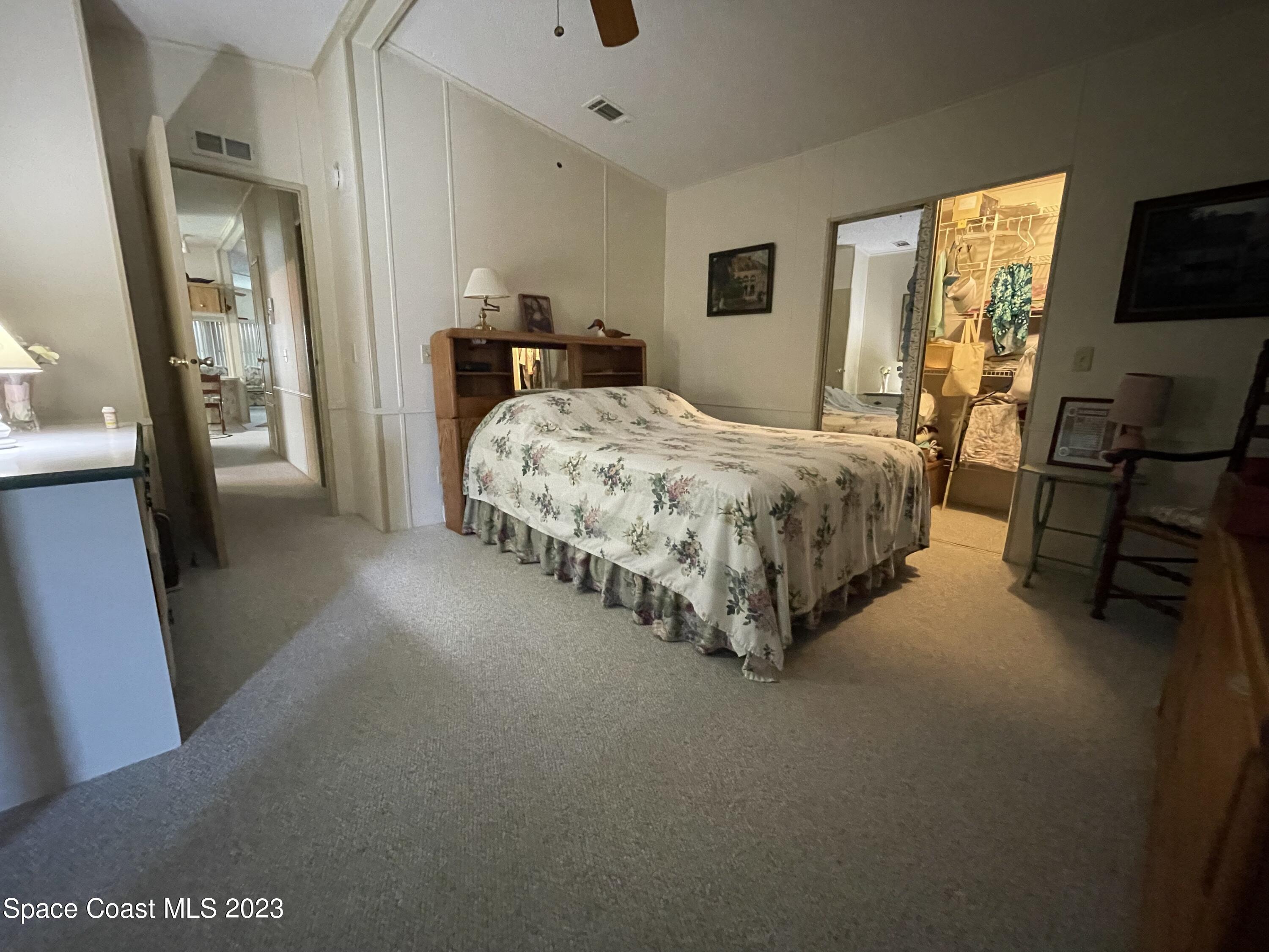 906 Oleander Circle Sebastian, FL 32976 - Photo 16 of 24 a spacious bedroom with a bed and dresser with mirror