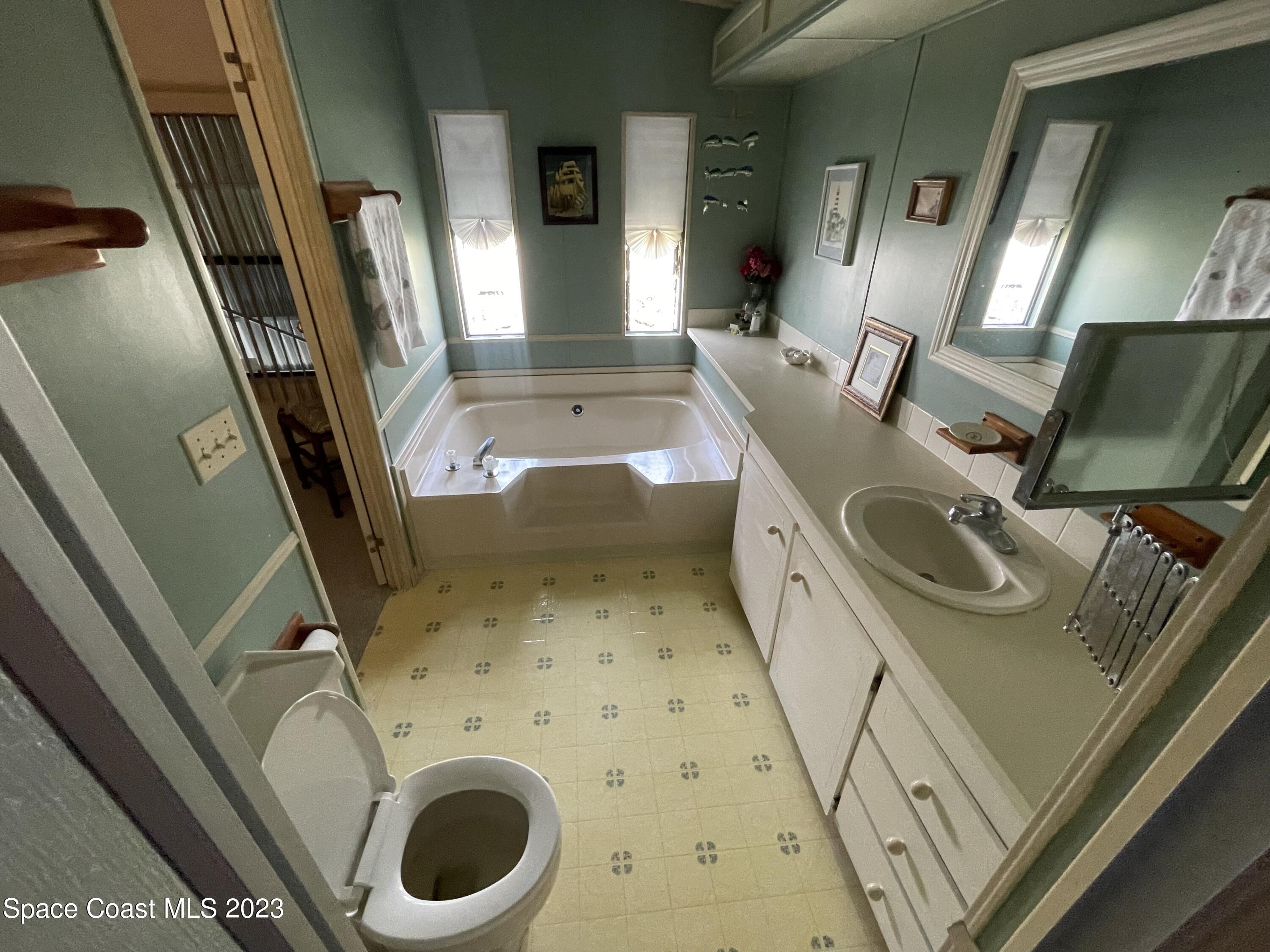 906 Oleander Circle Sebastian, FL 32976 - Photo 17 of 24 a bathroom with a sink a toilet and a mirror