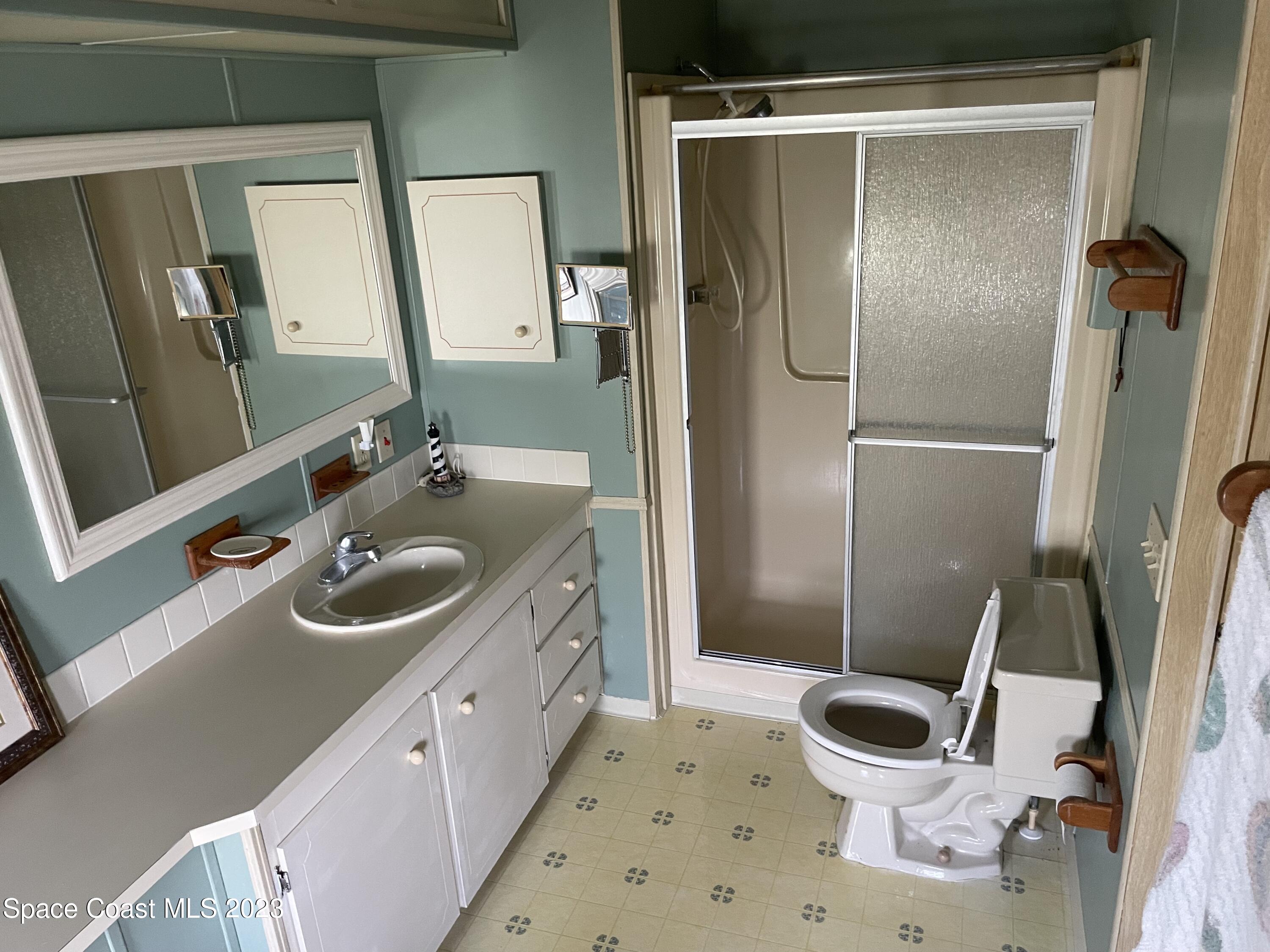 906 Oleander Circle Sebastian, FL 32976 - Photo 18 of 24 a bathroom with a sink a toilet and a mirror