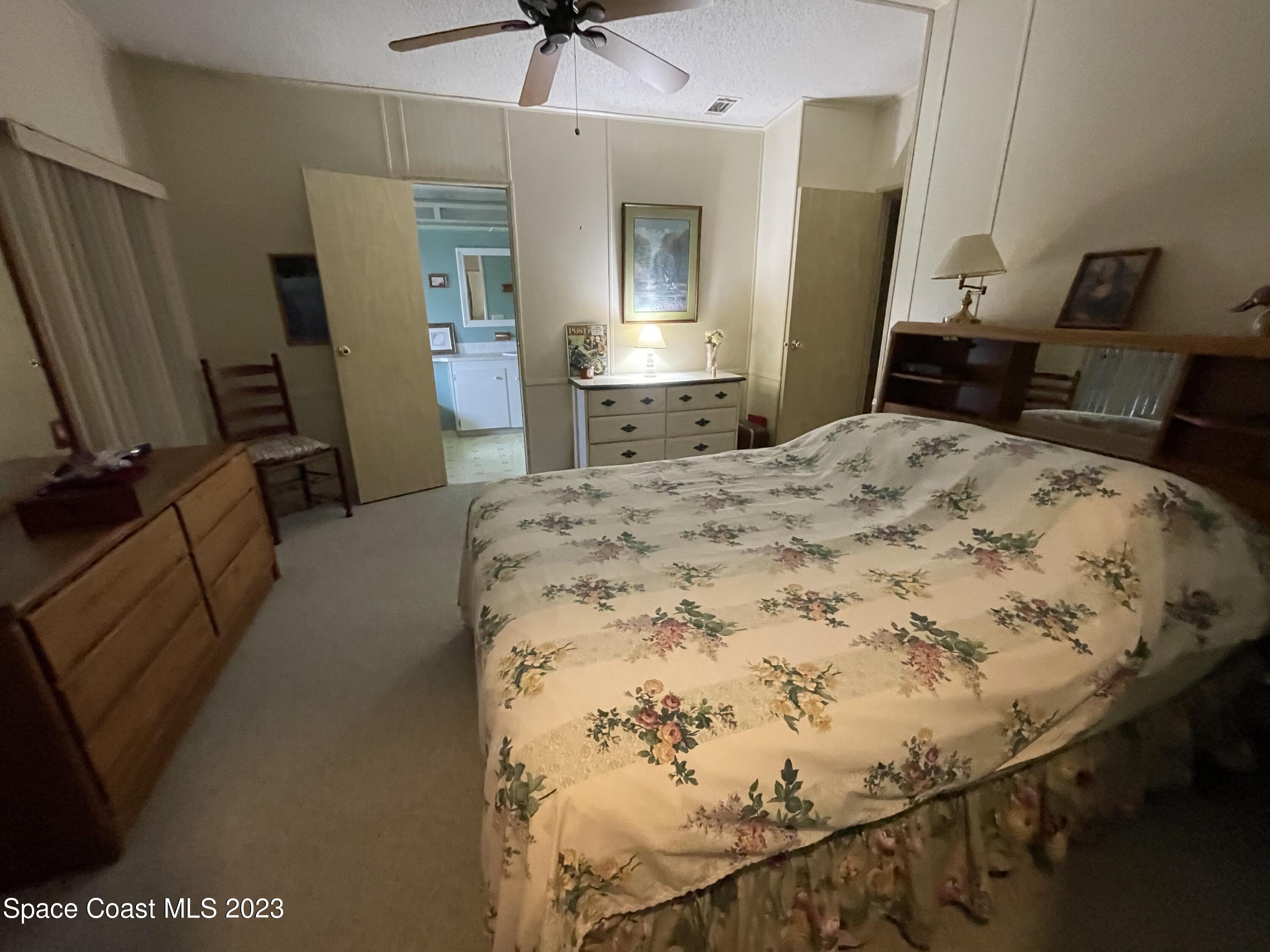 906 Oleander Circle Sebastian, FL 32976 - Photo 20 of 24 a bedroom with a bed and a flat tv screen on dresser