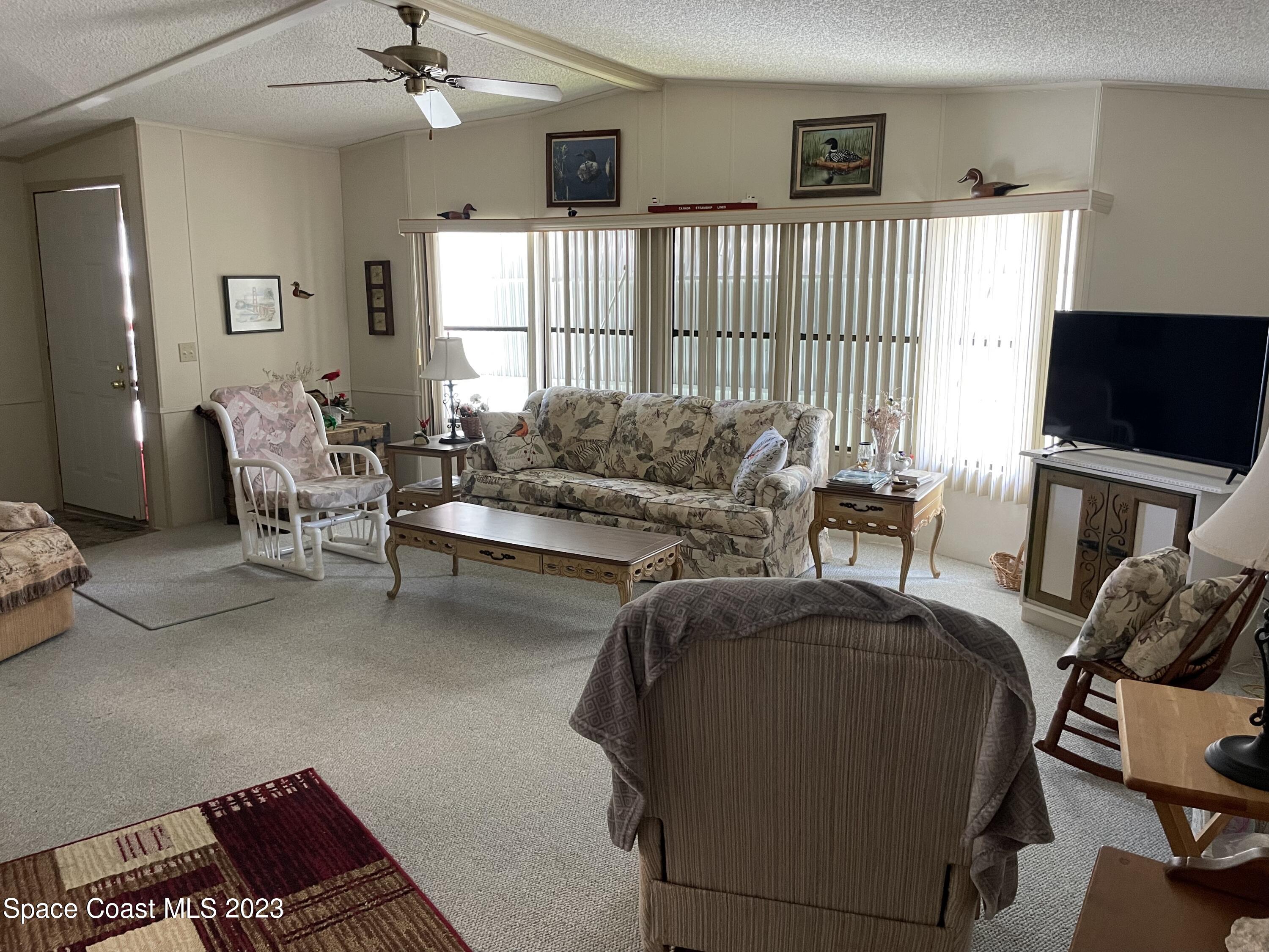 906 Oleander Circle Sebastian, FL 32976 - Photo 3 of 24 a living room with furniture and a flat screen tv