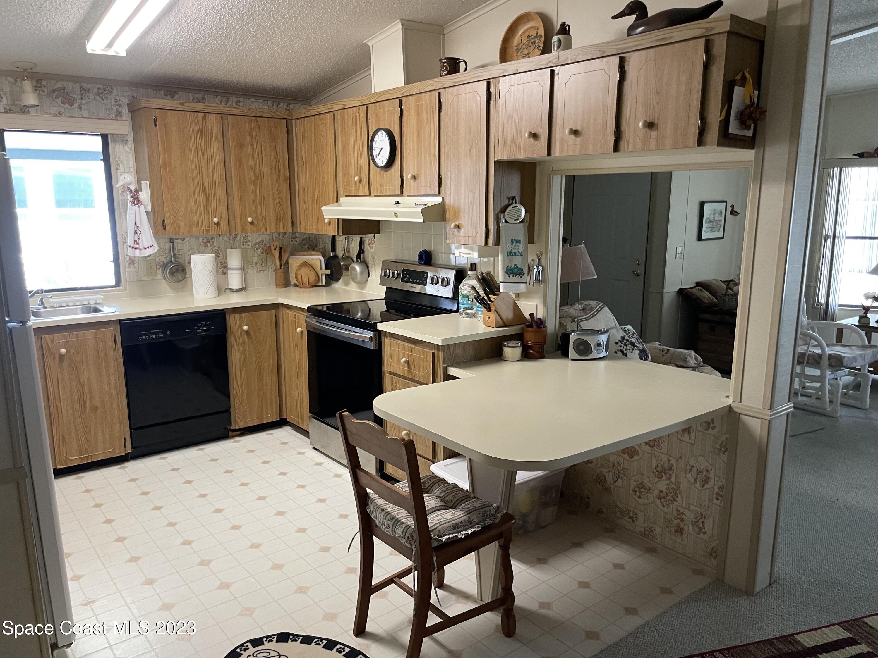 906 Oleander Circle Sebastian, FL 32976 - Photo 7 of 24 a kitchen with stainless steel appliances kitchen island a table chairs and a refrigerator