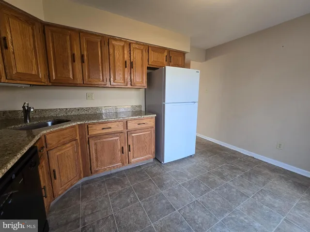 a kitchen with stainless steel appliances granite countertop a refrigerator a stove top oven and cabinets