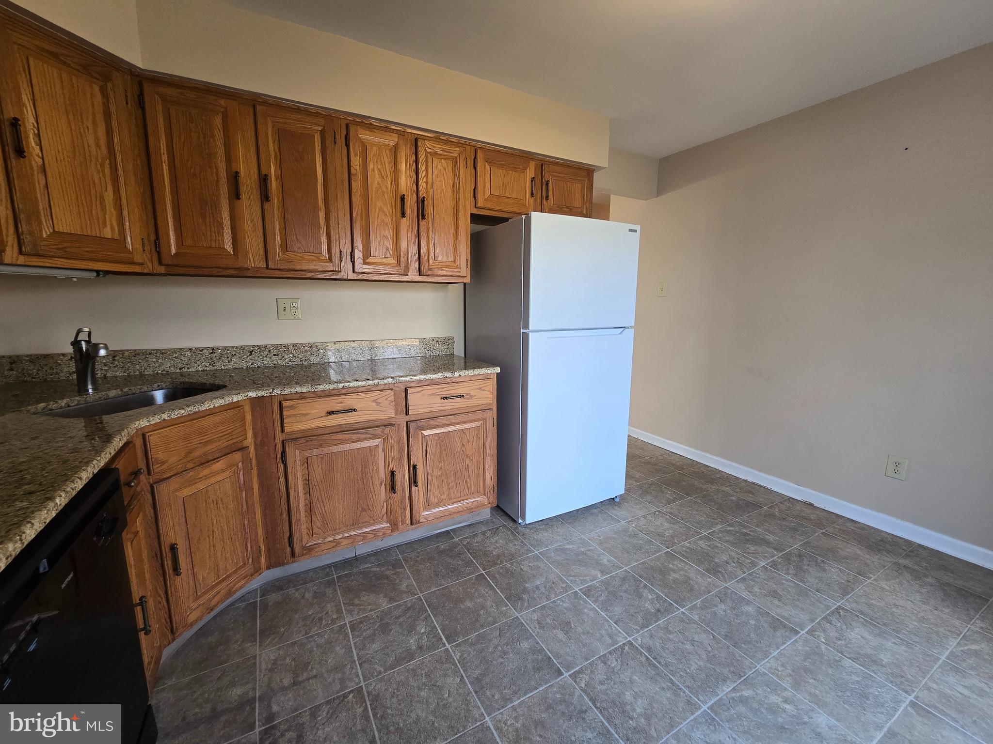 1769 North Dove Road, Unit A Yardley, PA 19067 - Photo 5 of 13 a kitchen with stainless steel appliances granite countertop a refrigerator a stove top oven and cabinets